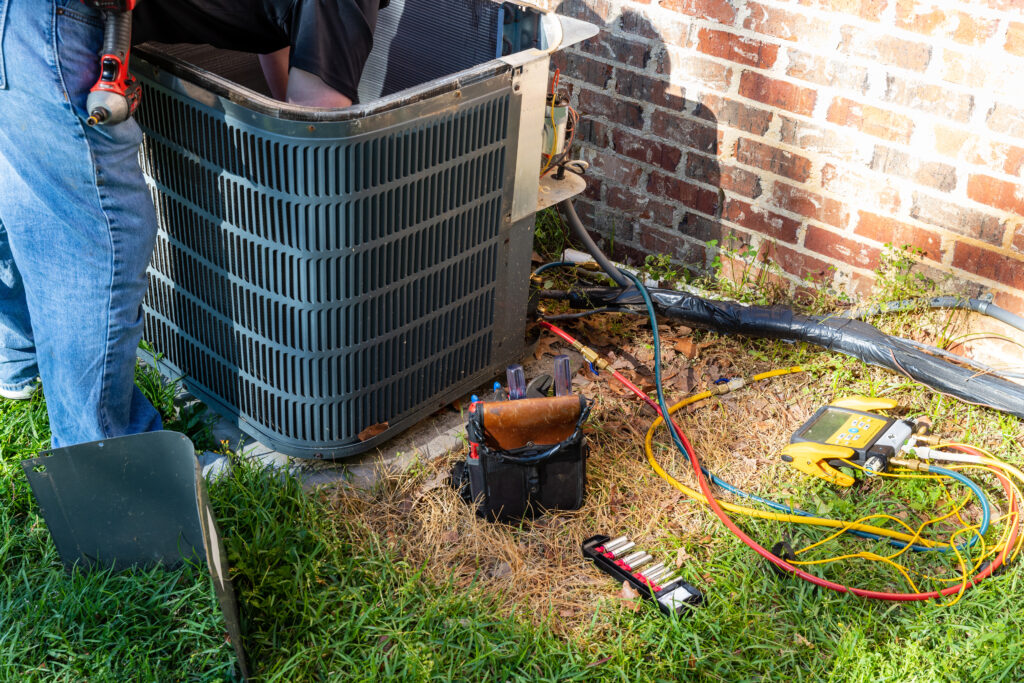 AC Maintenance in Ogden UT | JTG Plumbing Heating & Air | JTG Plumbing Heating & Air AC maintenance service being performed on outdoor unit in Ogden Utah