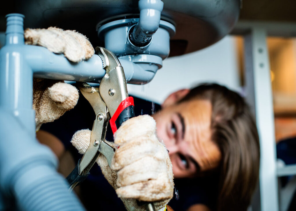 Plumbing Services in Salt Lake and Davis County | JTG Plumbing Heating & Air | JTG Plumbing Heating & Air Professional plumbers in Salt Lake City from JTG Plumbing repairing burst pipe during emergency plumbing service