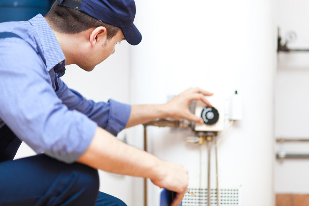 Water Heater Replacement in Northern Utah Davis and Weber County Plumbing services by JTG Plumbing Heating & Air | JTG Plumbing Heating & Air | JTG Plumbing Heating & Air Professional plumber from JTG Plumbing Heating & Air installing a new water heater in a Northern Utah home
