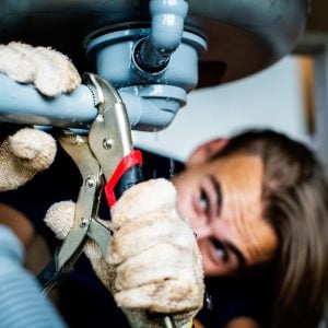 Professional plumbers in Salt Lake City from JTG Plumbing repairing burst pipe during emergency plumbing service